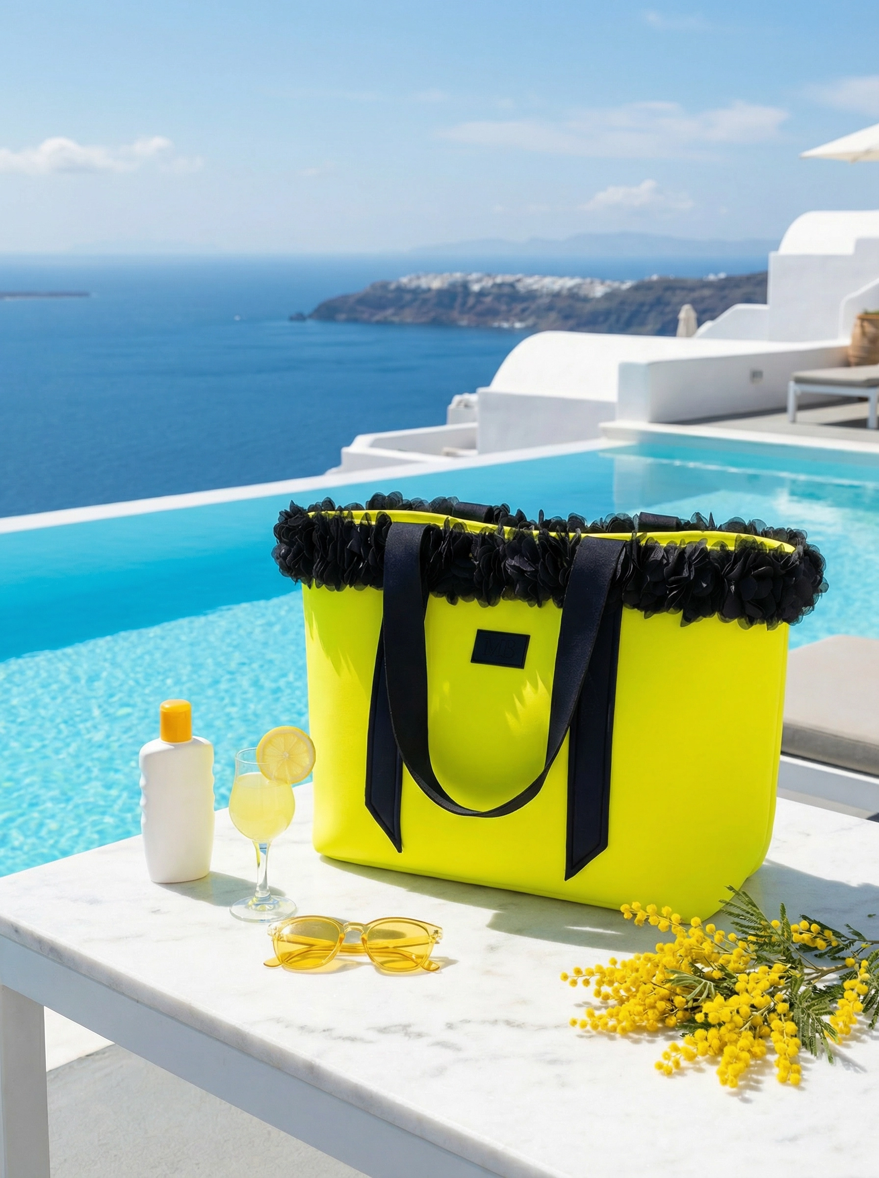 Yellow tote bag with black trim on a table by a pool with ocean view